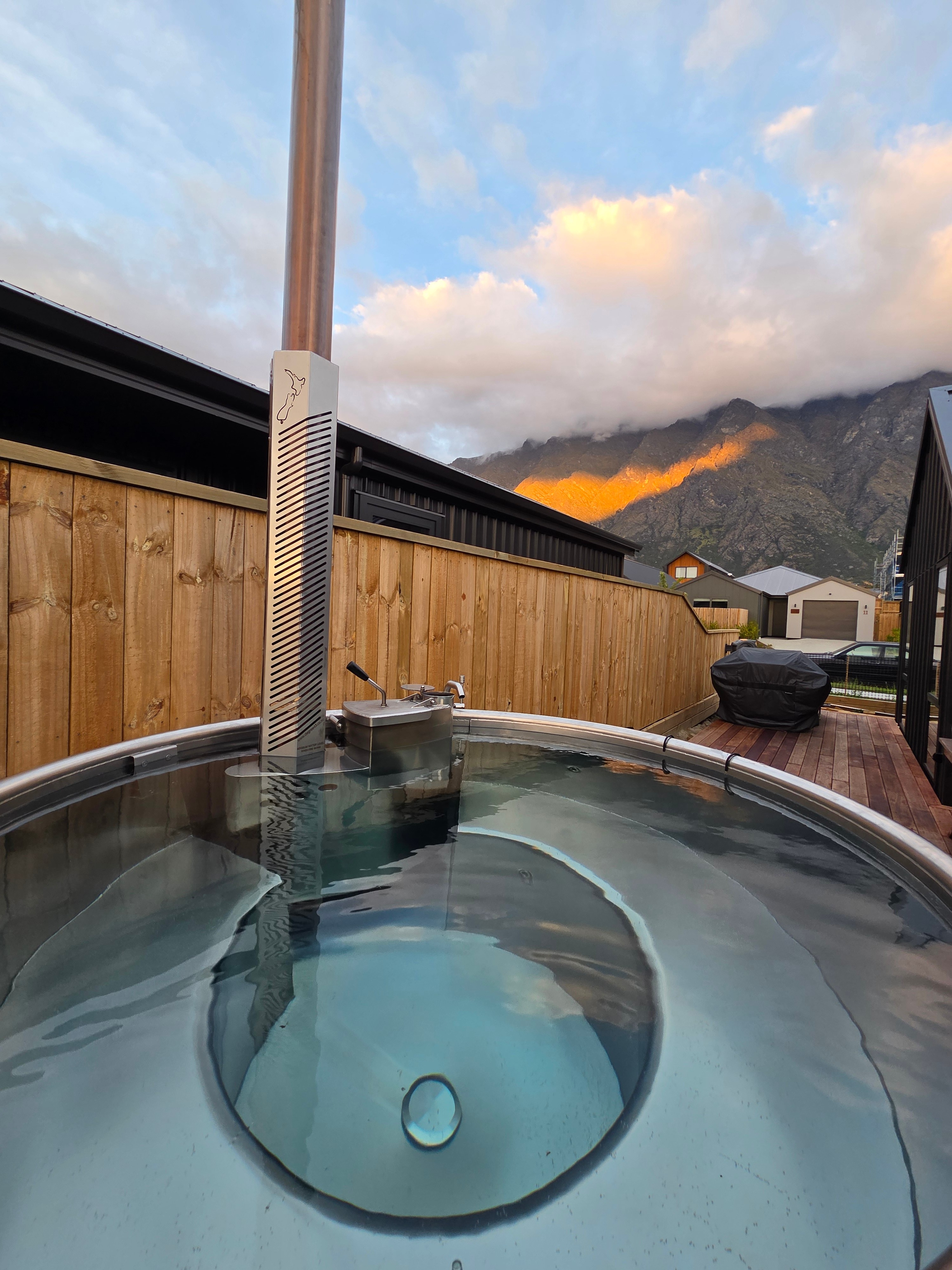 Our wood-fired hot tub on the deck at dusk, with alpenglow on The Remarkables